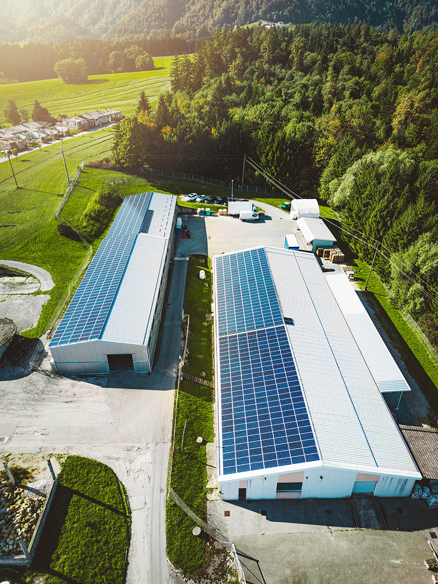 The sun is peeking through some commerical buidling shining on solar panels, use Solar Energy Partners for your commercial solar company today. 