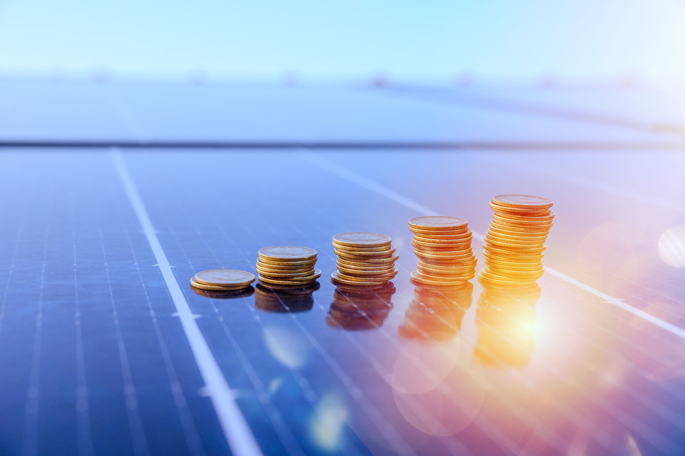 Coins stacked on solar panels, use Solar Energy Partners solar power installers in SC & GA for financing.