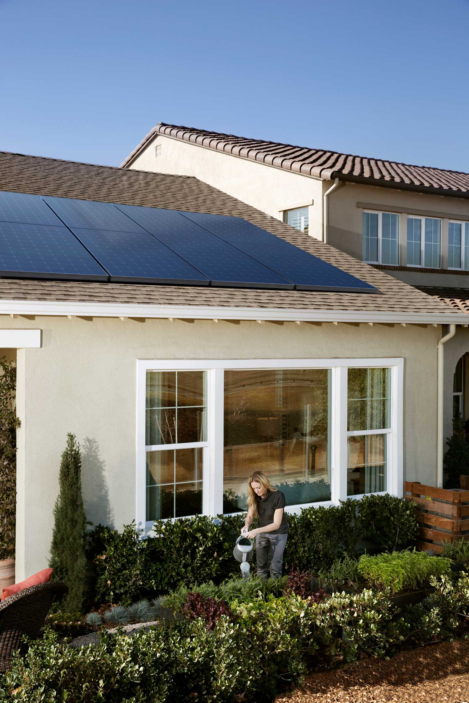 Solar Energy Partners SunPower installers in SC & GA, a women gardening outside by her new solar panels.