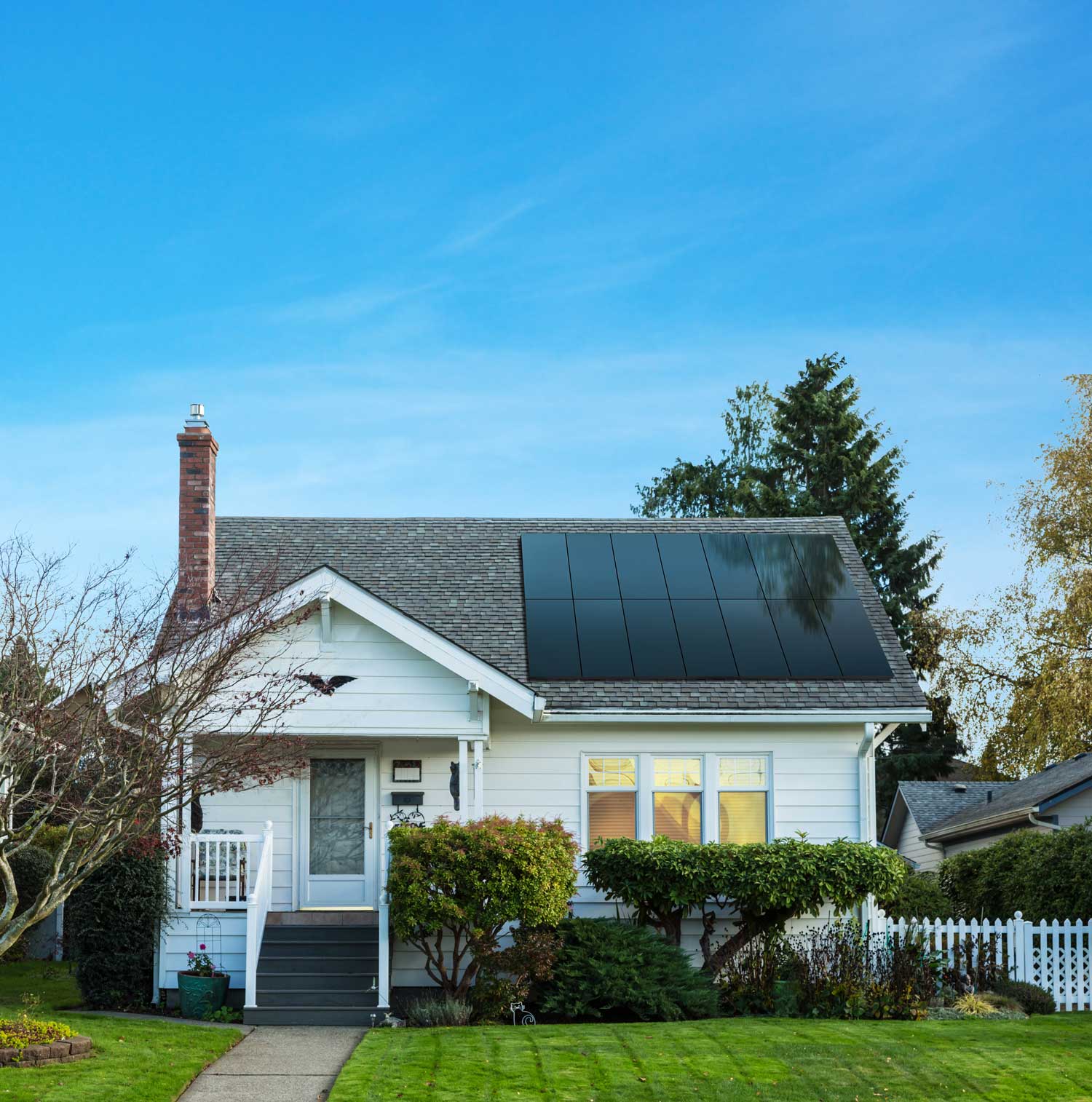 A small white house with freshly installed solar panels provided by Solar Energy Partners.